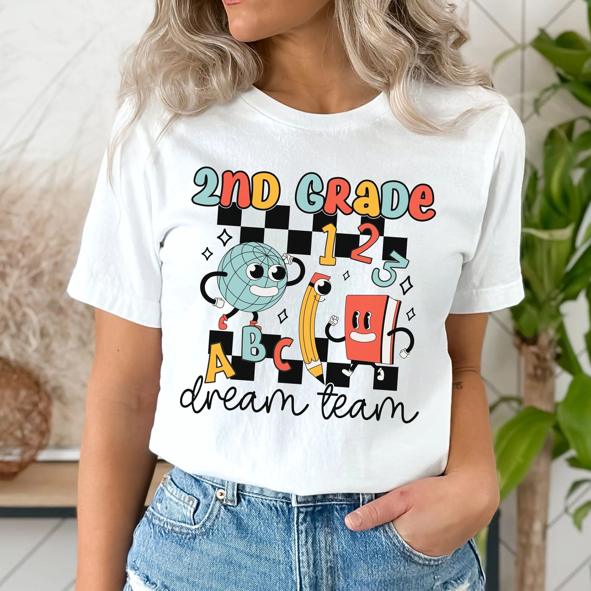 Show off your team spirit with the "2nd Grade Dream Team" T-shirt from TeachingTeez.com! Featuring a fun, retro checkered print with colorful clipart of a globe, pencil, and book, this trendy teacher tshirt is perfect for 2nd-grade teachers looking to add some style to their wardrobe. Made from soft, high-quality fabric, it's comfortable enough to wear all day. Whether you're looking for cute teacher shirts to rock in the classroom or a great gift for a fellow teacher, this t-shirt is a must-have. Shop now 