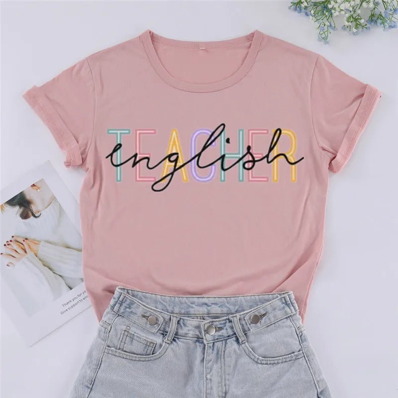 Front view of a stylish 'English Teacher' t-shirt in a nude color, featuring bold black lettering overlaying colorful 'Teacher' text. Perfect for showcasing your passion as a cute teacher t-shirt. Shop today at TeachingTeez.com!