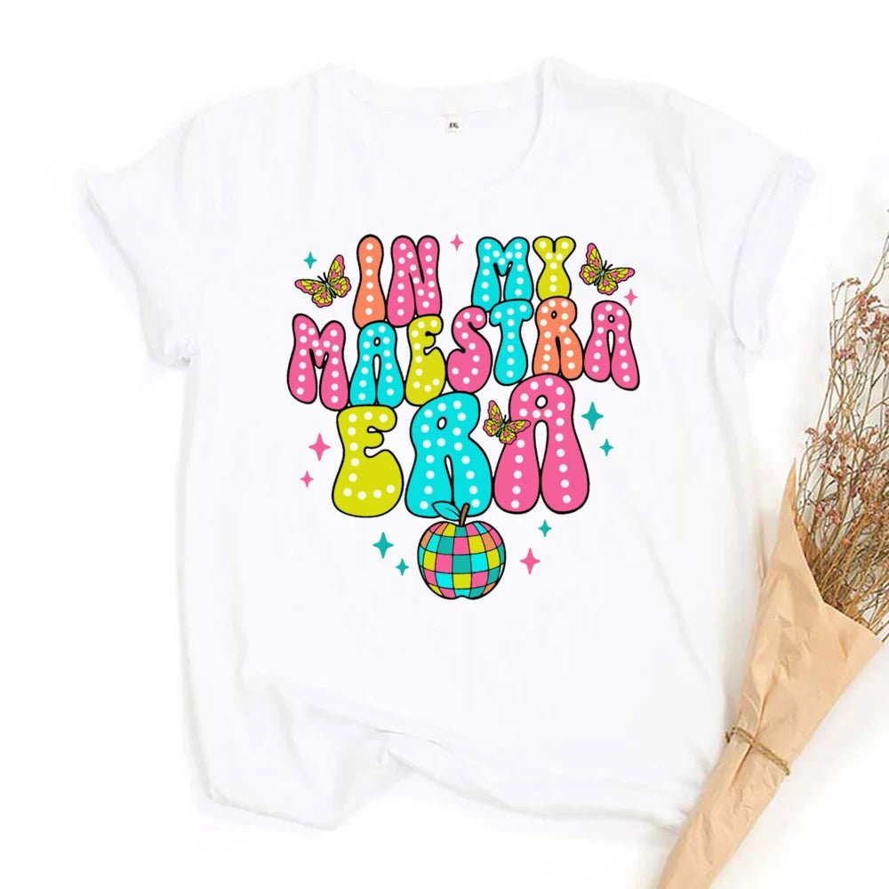 "In My Maestra Era" T-Shirt - TeachingTeez.com. Teacher tshirt in vibrant colors featuring a disco apple and butterflies. Shop today at TeachingTeez.com!