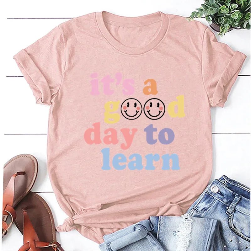 Lotus Root Color shirt Flat lay of the "It's a Good Day to Learn" t-shirt featuring colorful, playful lettering with smiley faces in the "O"s of "Good," crafted from soft fabric for comfort—shop today and spread positivity!