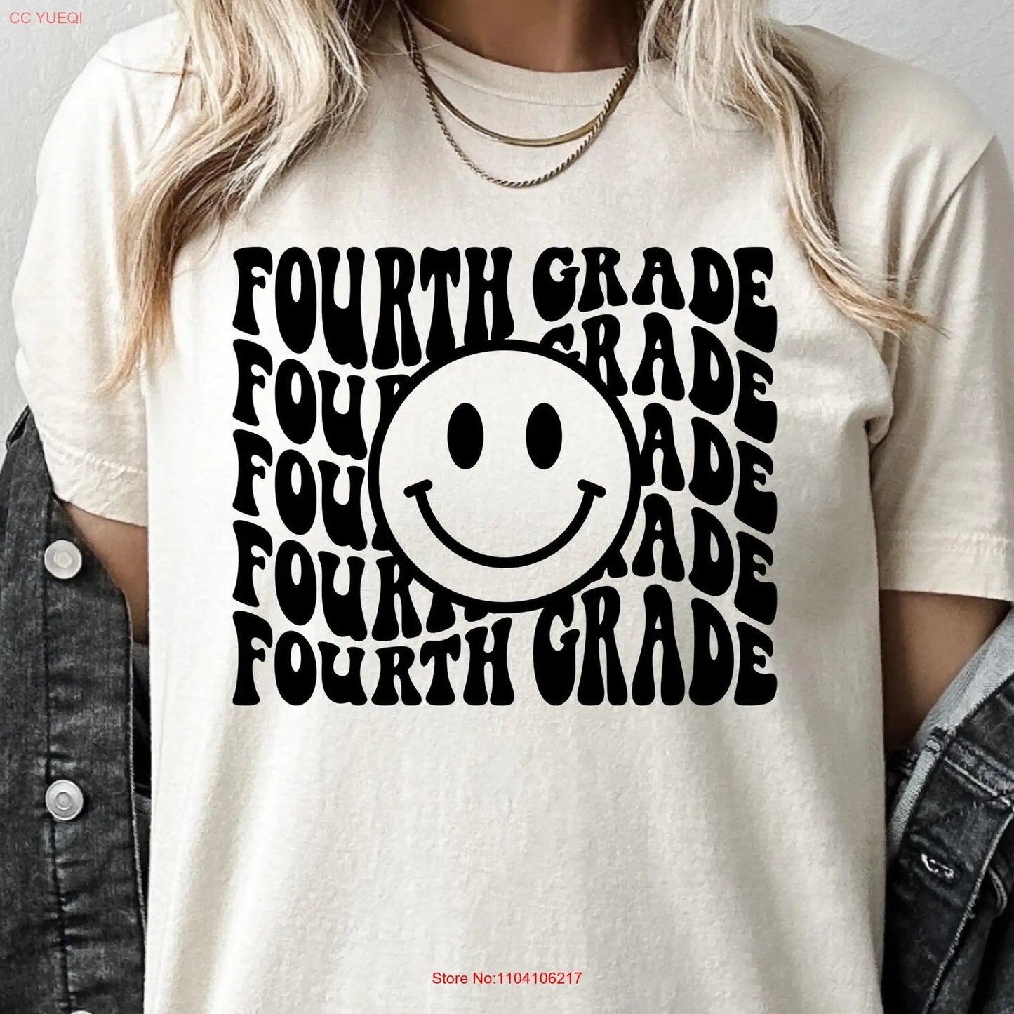 White t-shirt featuring the words "Fourth Grade" stacked vertically in bold black wavy font, centered around a large, cheerful smiley face. This playful and retro-inspired design is perfect for fourth-grade teachers looking to add a touch of vintage style to their classroom wardrobe. Available at TeachingTeez.com.